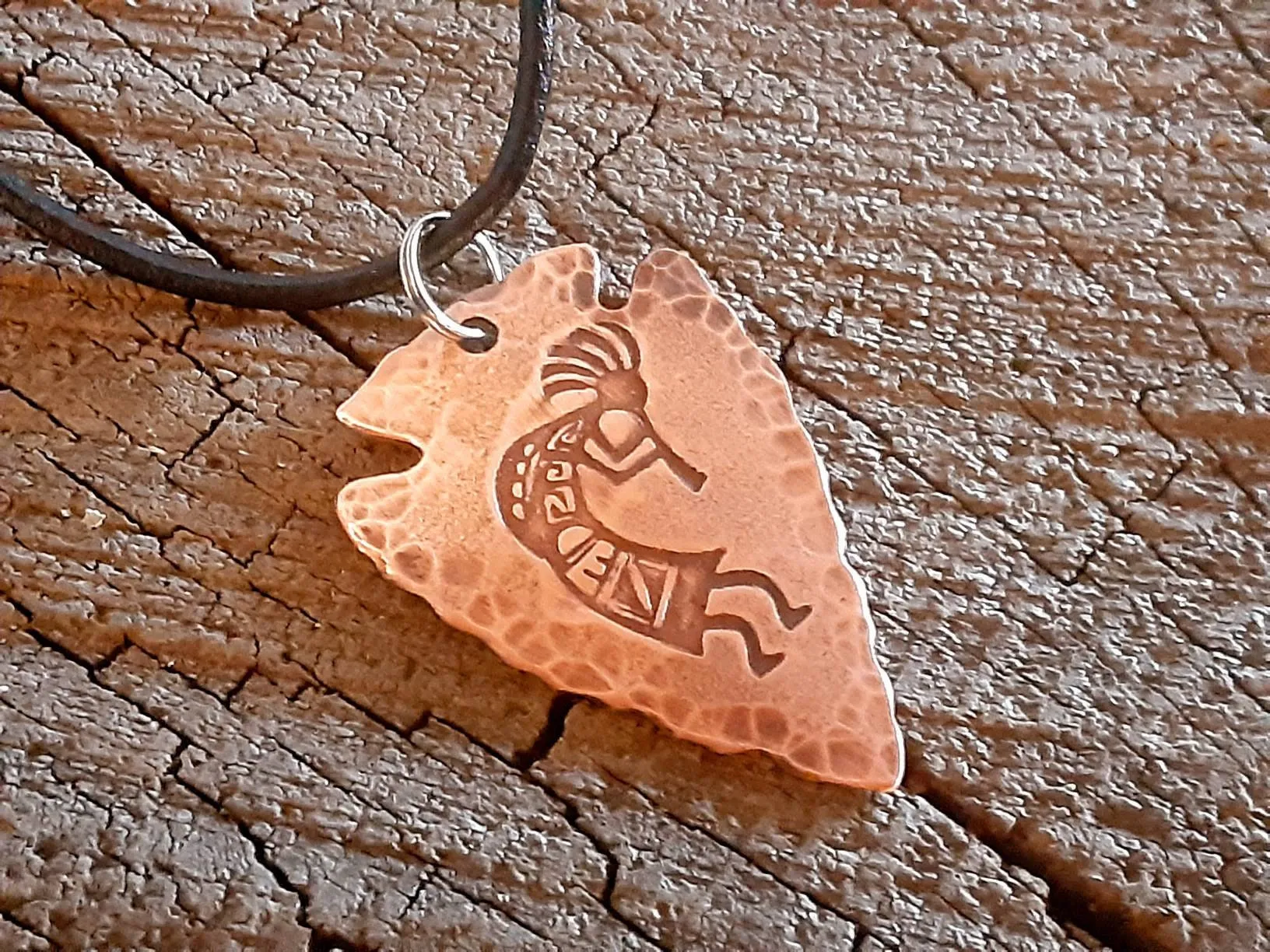Copper arrowhead necklace with Kokopelli hung from an adjustable leather cord