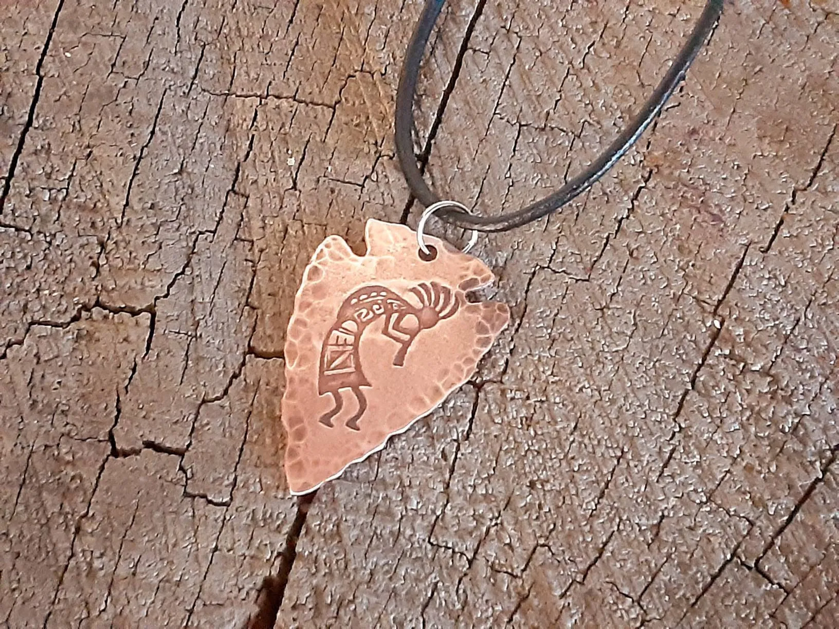 Copper arrowhead necklace with Kokopelli hung from an adjustable leather cord