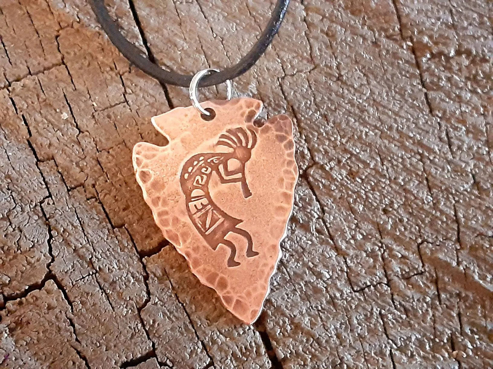 Copper arrowhead necklace with Kokopelli hung from an adjustable leather cord