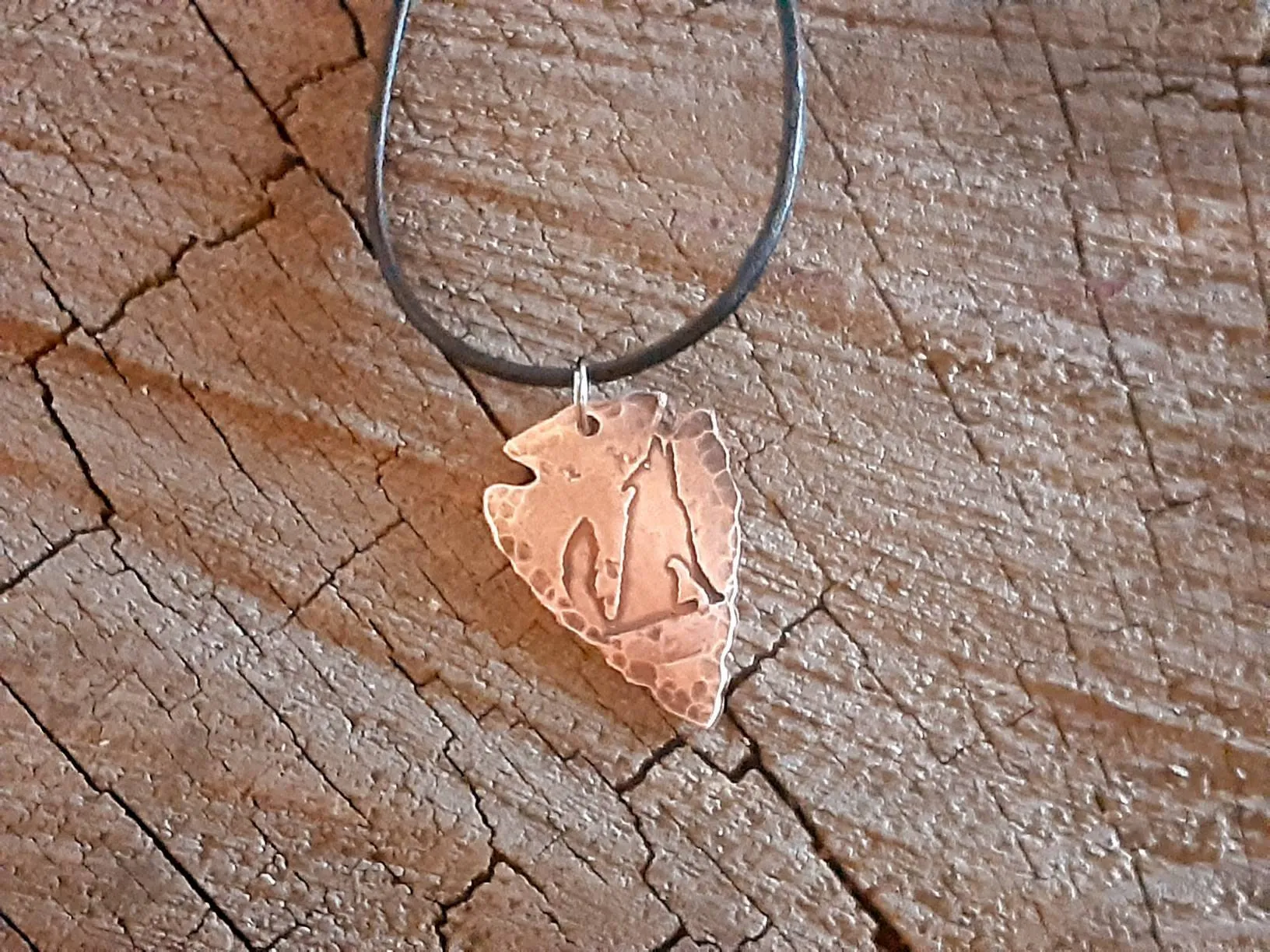 Men's copper arrowhead necklace with howling coyote and an adjustable leather cord