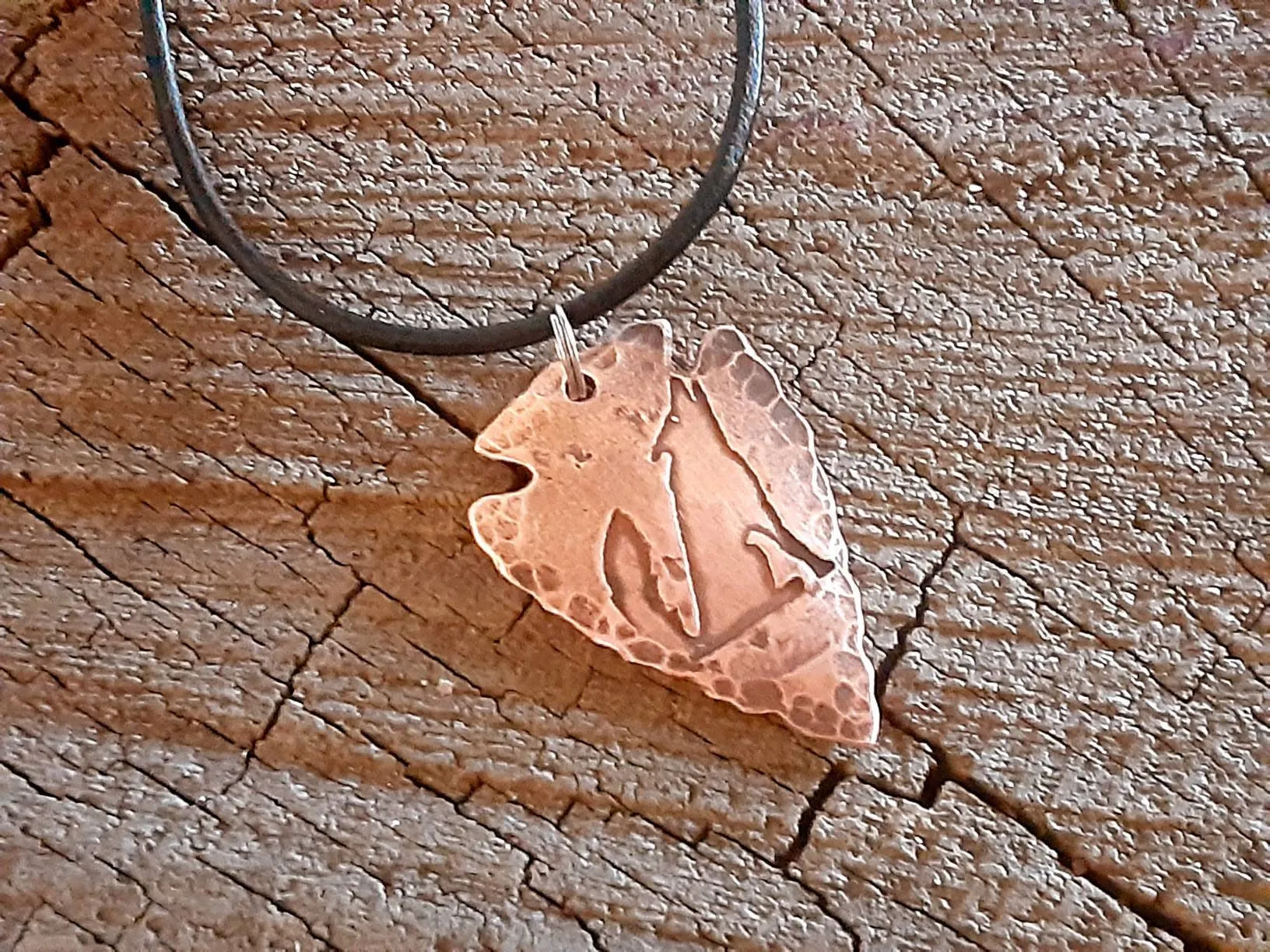 Men's copper arrowhead necklace with howling coyote and an adjustable leather cord